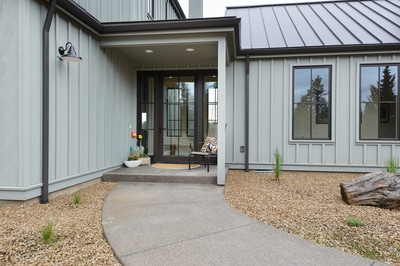 Exterior entryway with glass doors at Custom home in Bend Oregon built on private acreage in modern farmhouse style by Structure Development NW a home builder in Central Oregon.
