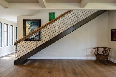 Interior custom wood and metal staircase with hardwood floors in Custom home in Bend Oregon built on private acreage in modern farmhouse style by Structure Development NW a home builder in Central Oregon.