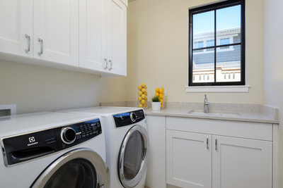 Interior laundry room with white appliances and cabinets in Custom home in Bend, Oregon Northwest Crossing built by Structure Development NW an award winning homebuilder in Central Oregon. Farmhouse Style home with stunning interior design.